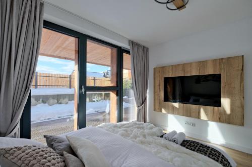 sypialnia z łóżkiem i telewizorem na ścianie w obiekcie Apartament Morskie Oko Odkryj Zakopane w Zakopanem