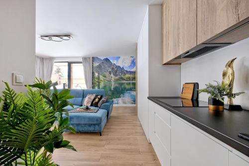 cocina con sala de estar con sofá azul en Apartament Morskie Oko Odkryj Zakopane, en Zakopane