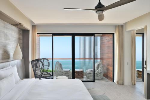 a bedroom with a bed and a view of the ocean at The Westin Resort & Spa Himalayas in Rishīkesh