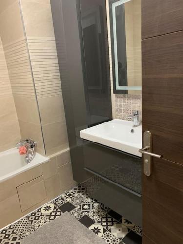 une salle de bain avec un lavabo, un miroir et une baignoire dans l'établissement Apartment in the Heart of The Champs Elysées with Balcony, à Paris