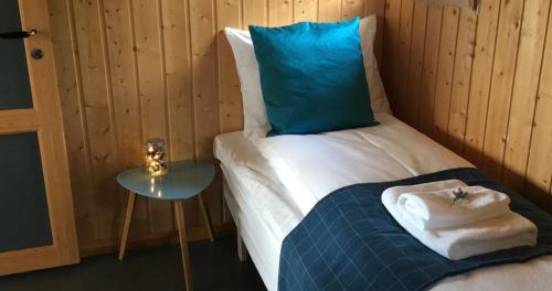 a bedroom with a bed with a blue pillow and a table at Tustna Ladestasjon in Hals