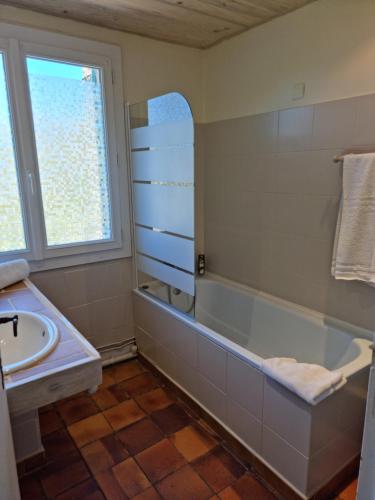 a bathroom with a tub and a sink at Logis Hôtels Le Saint Marc in Mollans-sur-Ouvèze
