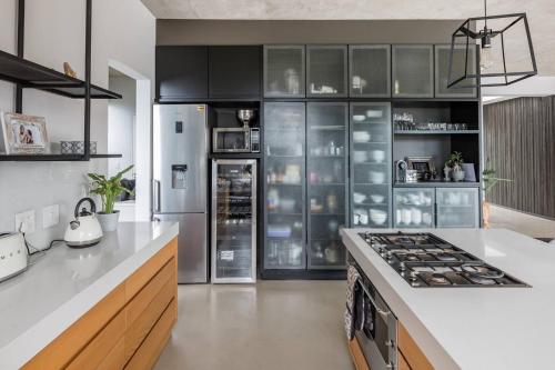 a kitchen with black cabinets and a stove top oven at Maison De Plage in Umdloti