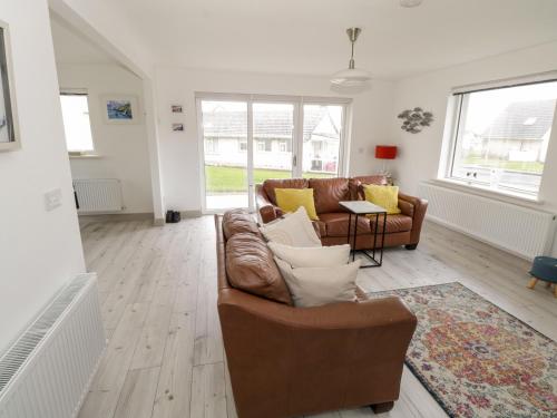 a living room with a couch and a table at 38 Carrowhubbock Holiday Village in Enniscrone