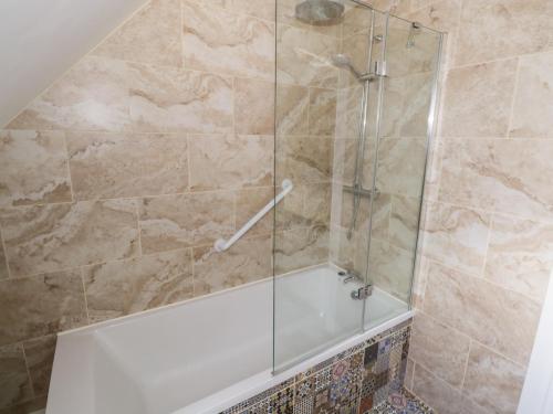 a bathroom with a shower with a white tub at 38 Carrowhubbock Holiday Village in Enniscrone