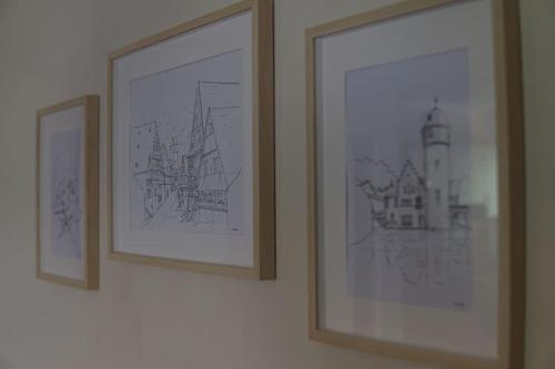 two framed drawings of a lighthouse are hanging on a wall at Räuberlager 15 in Dammbach