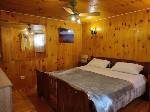 a bedroom with a bed in a wooden wall at Robinson Galisnjak with amazing SEA VIEW & JACUZZI in Bol