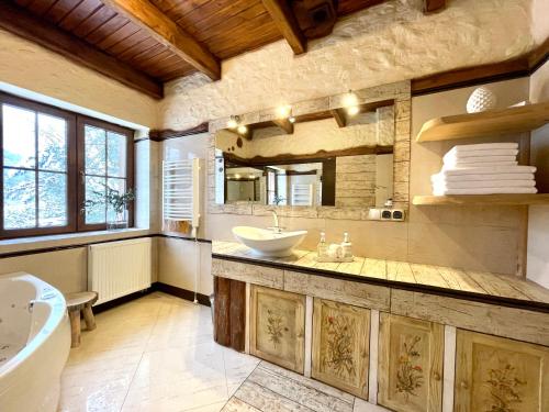 ein großes Badezimmer mit einem Waschbecken, einer Badewanne und einem Tubermott in der Unterkunft Domek na Cuplu - opcjonalnie balia jacuzzi in Szczyrk