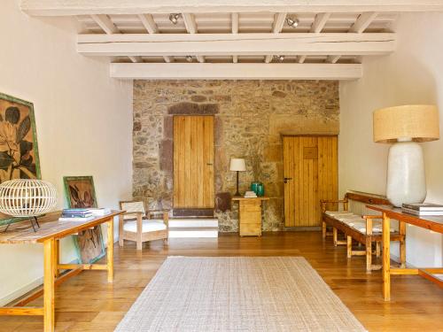 a living room with wooden furniture and a stone wall at Les Canes 2 in Aiguafreda