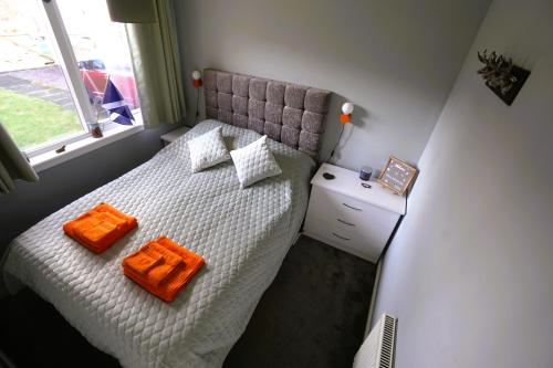 a bedroom with a bed with two orange towels on it at Cosy double room in peaceful location, Ballachulish nr Glencoe Highlands in Ballachulish
