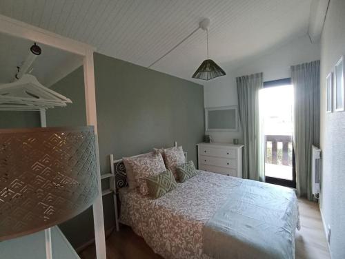 sypialnia z łóżkiem, komodą i oknem w obiekcie Le Petit Eden des Dunes w mieście Seignosse