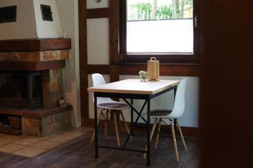 a table and chairs in a room with a fireplace at Räuberlager 15 in Dammbach