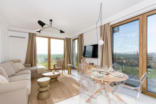 a living room with a couch and a table with chairs at Bursztynowe Tarasy - Apartamenty in Gdańsk