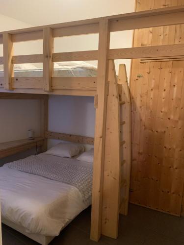une chambre avec deux lits superposés avec des draps blancs dans l'établissement Appartement Matiski, à Vaujany