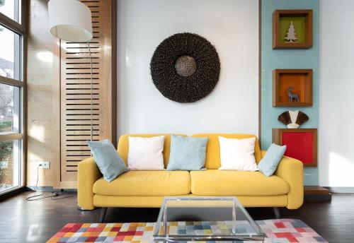 ボンにあるnuma I Bona Rooms & Apartmentsのリビングルーム(黄色のソファ、テーブル付)