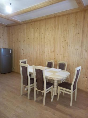 a dining room with a white table and chairs at У бабусі in Bursuchna