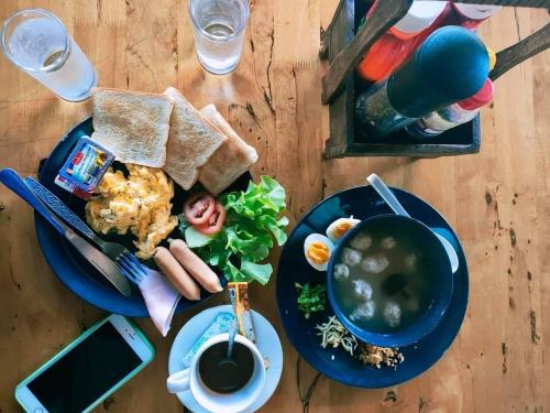 a table with a plate of food and a bowl of soup at The Lofthouse Sansai in Chiang Mai