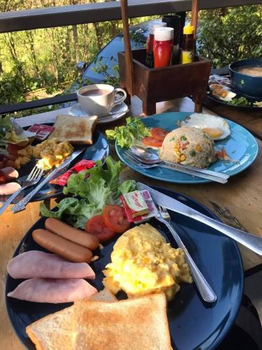 a table with plates of breakfast food on it at The Lofthouse Sansai in Chiang Mai
