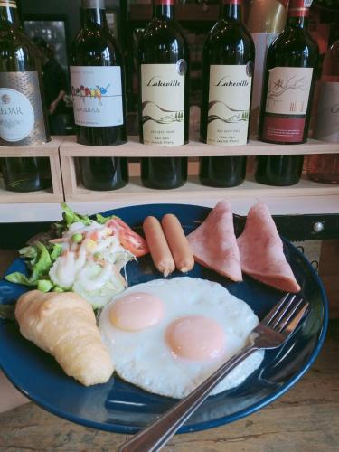 a plate of food with eggs and bread and wine bottles at The Lofthouse Sansai in Chiang Mai