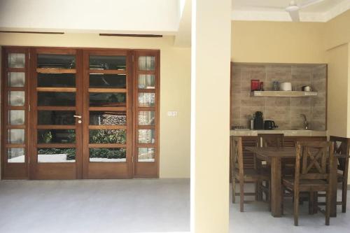 a dining room with a wooden door and a table at C9 @ Diani Beachalets in Galu