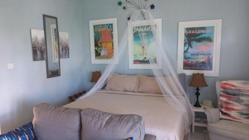 um quarto com uma cama com redes mosquiteiras em Beautiful Balcony by the Sea Studio em Ocho Rios