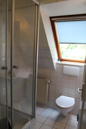 ein Bad mit einem WC und einer Glasdusche in der Unterkunft Gästehaus Nis Puk und Ferienwohnungen in Büsum