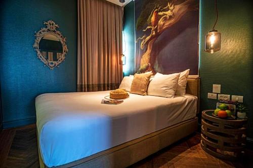 a bedroom with a large bed with a painting on the wall at Olive Gordon By The Beach in Tel Aviv