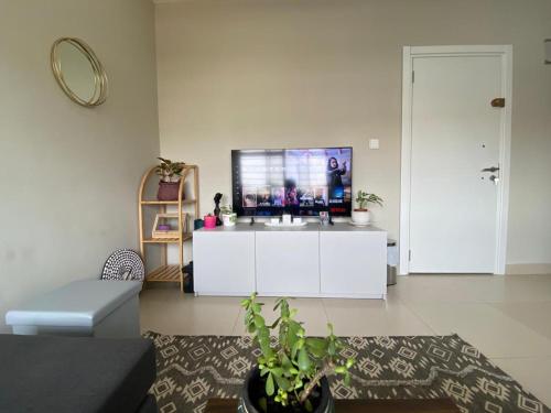 uma sala de estar com uma televisão num armário branco em Newly Renovated 1Bd Apt in Heart of Osu em Acra