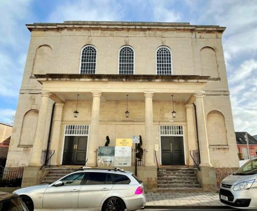 a white car parked in front of a building at Wesley House in Cheltenham