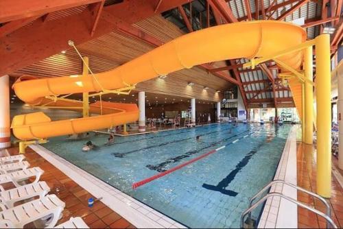 a large swimming pool with a slide in a building at Appartement Matiski in Vaujany