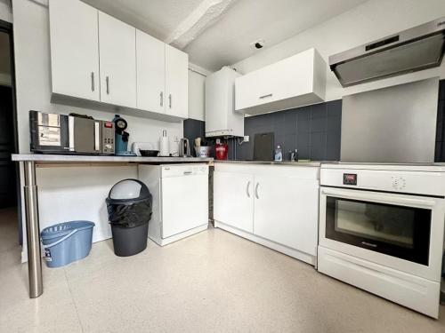 a kitchen with white cabinets and a counter top at Résidence Bury in Tulle