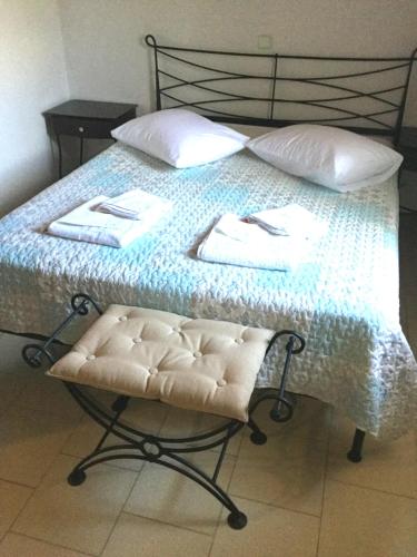 a bed with a chair with two towels on it at ARISTIDIS Apartments in Lefkimmi