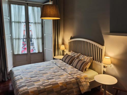a bedroom with a bed and two tables and a window at Charming view Plaza Mayor in Madrid