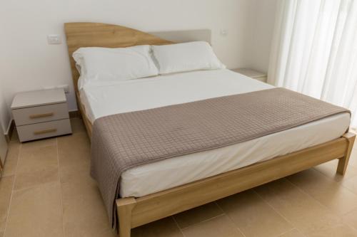 łóżko w sypialni z drewnianą ramą w obiekcie MareVasto - appartamento Vasto Marina w mieście Vasto