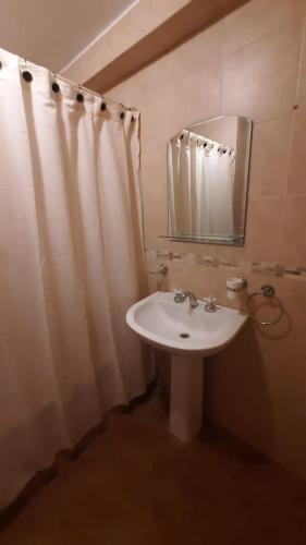 Departamento Virrey I في سالتا: حمام مع حوض أبيض ومرآة