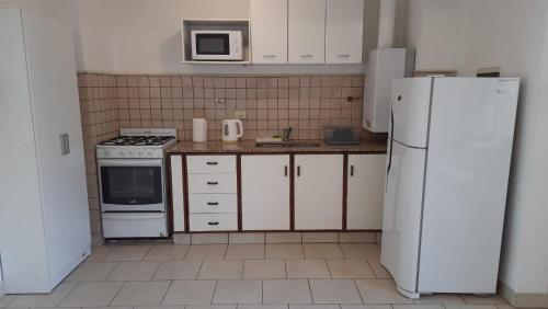 a kitchen with white appliances and a white refrigerator at Departamento Virrey I in Salta