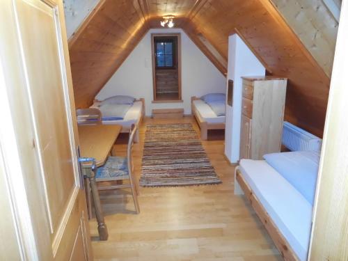 um quarto no sótão com uma mesa e uma cama em Ferienhaus Soghäusl em Göstling an der Ybbs