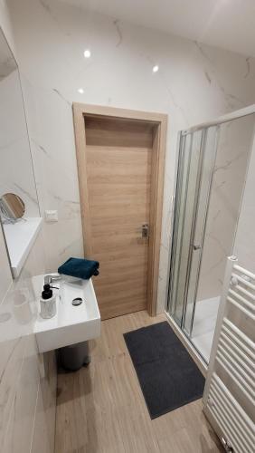 een badkamer met een wastafel en een houten deur bij Apartment house Tatras in Liptovský Mikuláš