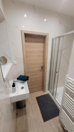 a bathroom with a sink and a wooden door at Apartment house Tatras in Liptovský Mikuláš