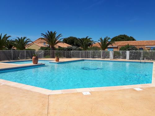 a large swimming pool with blue water at MARINES DU ROUSSILLON 78 - EN RESIDENCE AVEC PISCINE PROCHE PLAGE in Saint-Cyprien