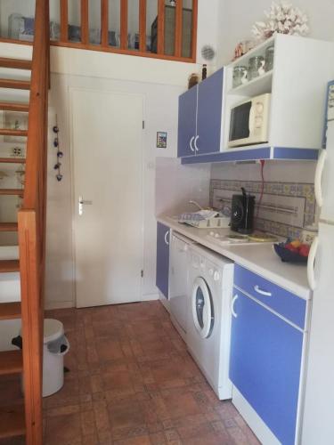 une petite cuisine avec un lave-linge et des armoires bleues dans l'établissement MARINES DU ROUSSILLON 78 -Villa 4 pers en résidence avec piscine à 150 m de la plage - Clim - parking, à Saint-Cyprien