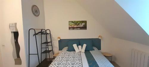 - une chambre avec un lit doté d'une tête de lit bleue et d'une horloge dans l'établissement Location Tame, à Douai