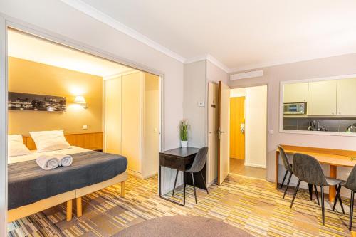 une chambre d'hôtel avec un lit et une table dans l'établissement Paris Expo Apart Hotel - Porte de Versailles - 2R & Parking, à Issy-les-Moulineaux