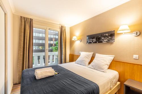 une chambre d'hôtel avec un lit et une fenêtre dans l'établissement Paris Expo Apart Hotel Porte de Versailles - Parking, à Issy-les-Moulineaux