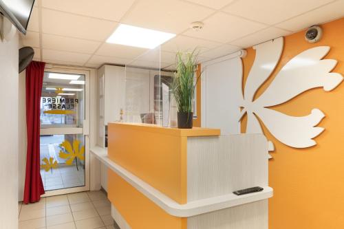 eine Lobby eines Ladens mit orangefarbenen und weißen Wänden in der Unterkunft Premiere Classe Fleury Merogis in Fleury-Mérogis