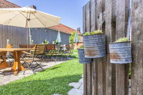 a fence with potted plants in buckets on it at Gasthof Schiesl in Altendorf