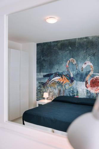 a bedroom with a bed and a painting of flamingos at Lamare cucina e dimore in Polignano a Mare