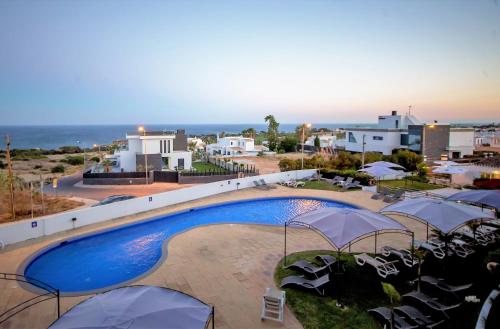 a view of a swimming pool with umbrellas at Hotel Maritur - Adults Only in Albufeira
