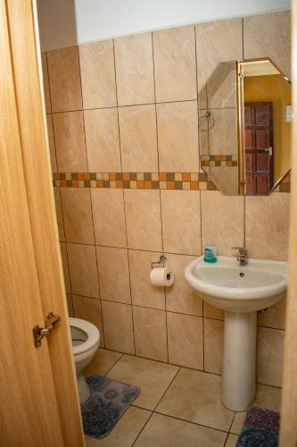un bagno con lavandino, WC e specchio di Josef Self Catering a Swakopmund