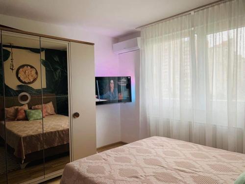 1 dormitorio con 1 cama y TV en la pared en M&M Apartment en Sarajevo